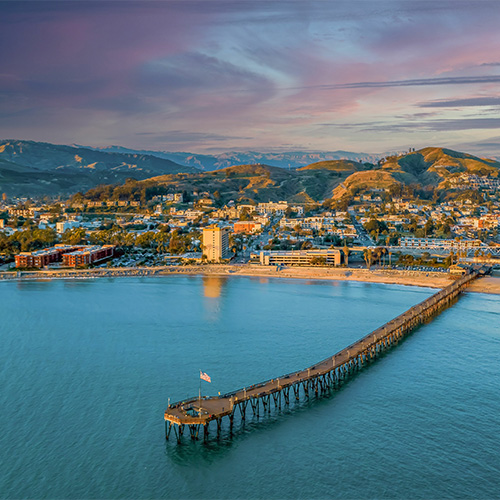 Aerial view of a pier and city coastline at sundown