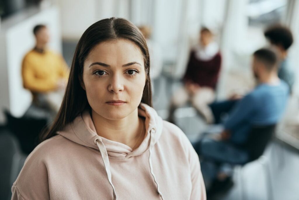 person in group therapy with intense facial expression while listening to others discuss answers to the question what is depression treatment